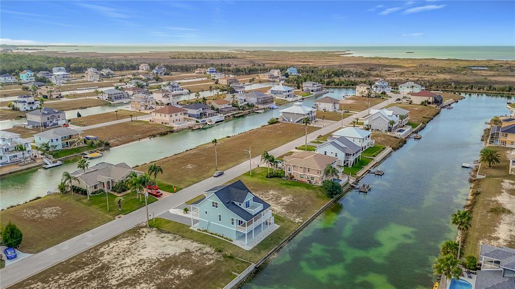 An aerial view shows waterfront houses along canals in a coastal residential neighborhood — 3487 SHEEPHEAD DRIVE, HERNANDO BEACH, FL