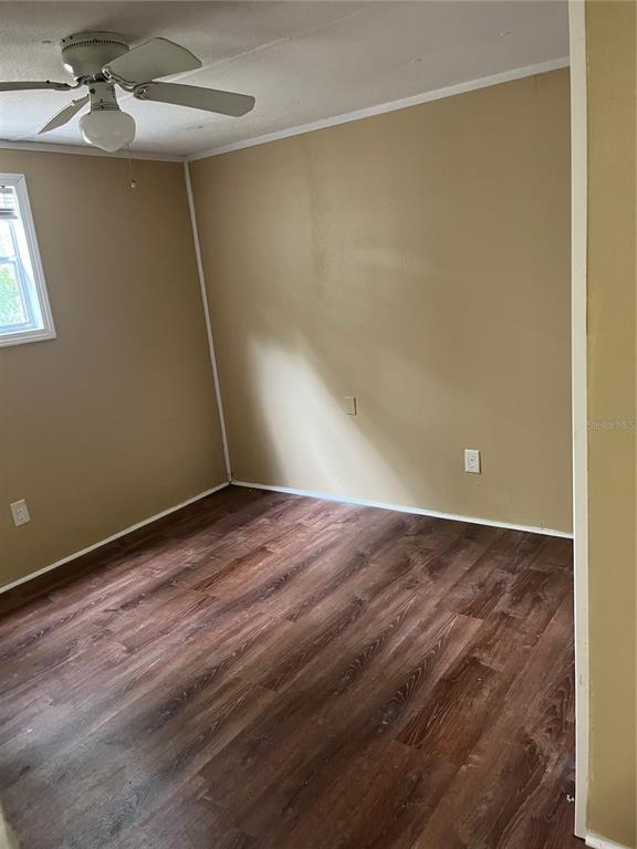A bedroom with tan walls, dark wood-look flooring, and a ceiling fan — 3000 CLARCONA ROAD UNIT 2824, APOPKA, FL