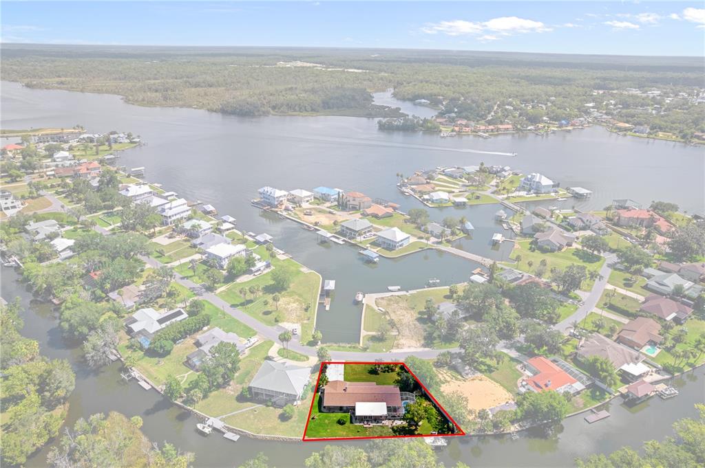 An aerial view shows a waterfront house with a red-outlined yard on a canal — 2160 N WATERSEDGE DRIVE, CRYSTAL RIVER, FL