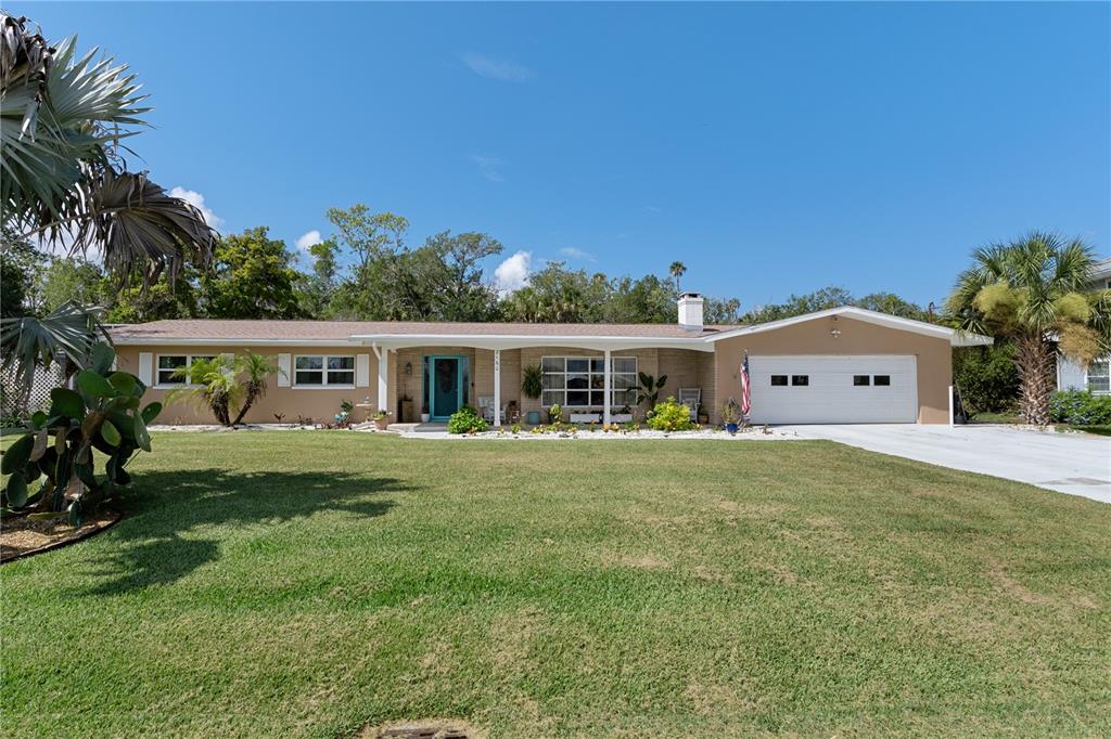 A single-story ranch-style house with a tan exterior, white garage door, and a front lawn — 2160 N WATERSEDGE DRIVE, CRYSTAL RIVER, FL