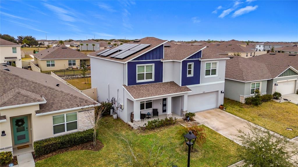 An aerial view of a two-story suburban house with solar panels on the roof — 4004 MALAWI TRAIL, ST CLOUD, FL