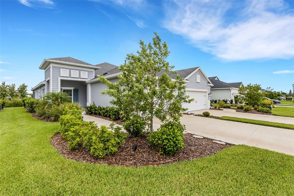 A light blue single-story house features a concrete driveway, a front garden, and a garage — 4657 WILLOW BEND AVENUE, PARRISH, FL