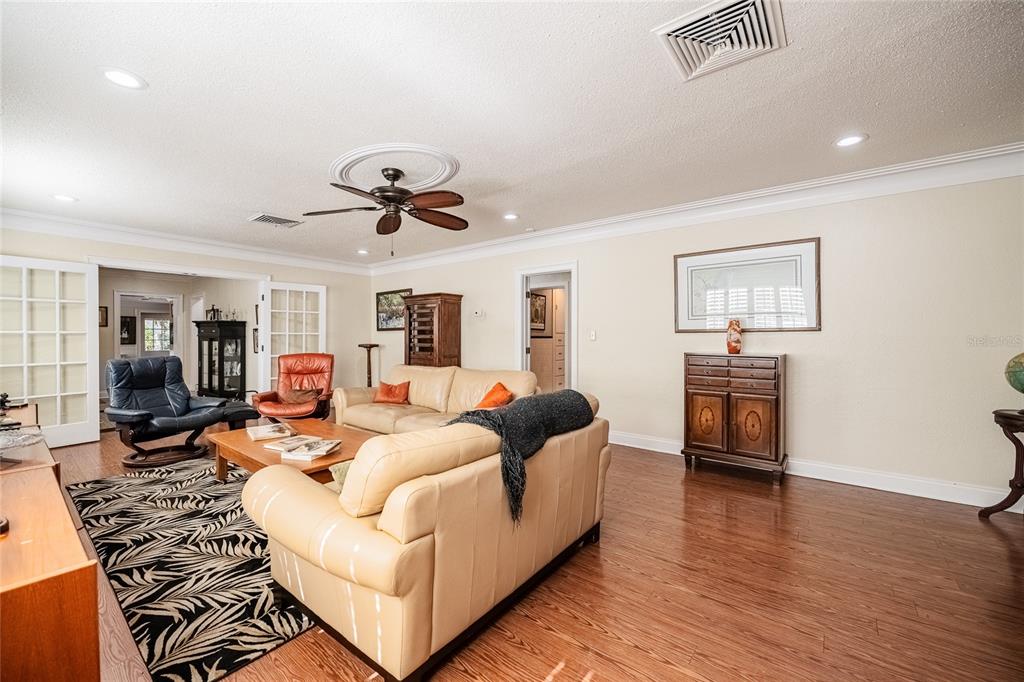 A living room with light-colored sofas, a patterned rug, and wood-look flooring — 2804 NEVADA ROAD, LAKELAND, FL
