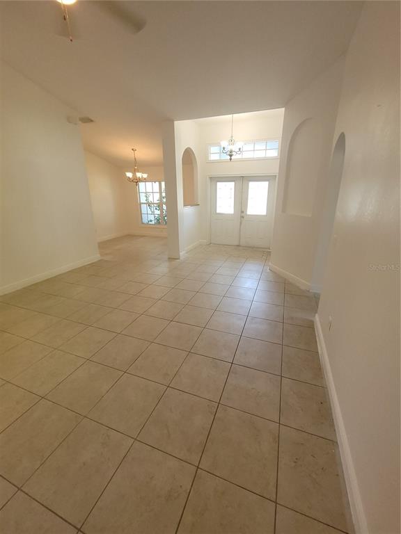 An entryway with tiled floors leads to a double door and an adjacent dining area — 1422 JAKWAY ROAD, NORTH PORT, FL