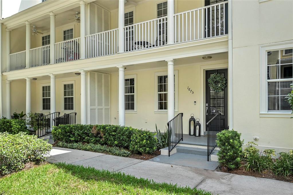 A two-story building exterior features a covered porch, white columns, and a black front door — 1675 PROSPECT AVENUE, ORLANDO, FL