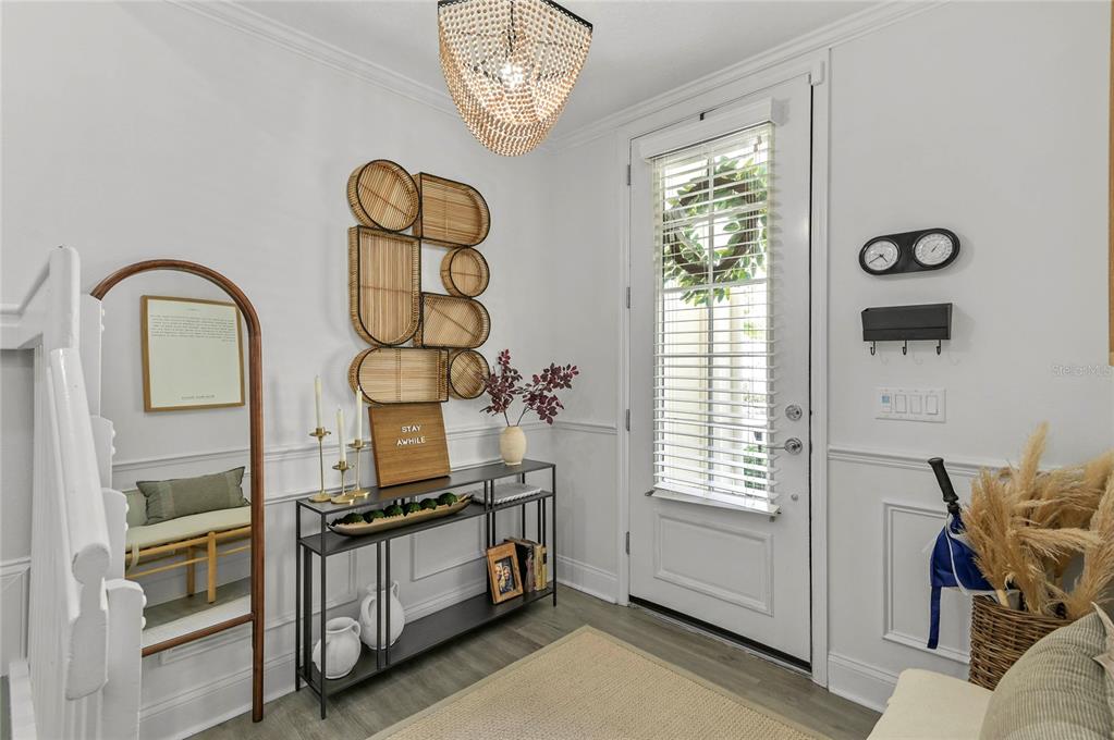 A bright entryway features a console table, a decorative wall display, and a front door — 1675 PROSPECT AVENUE, ORLANDO, FL
