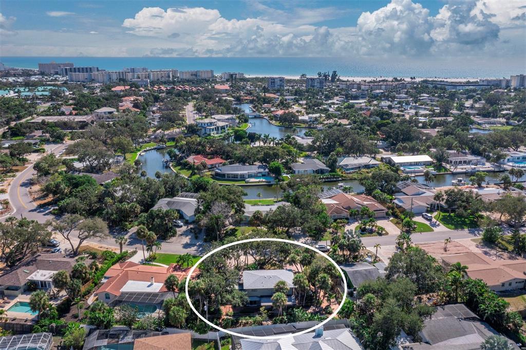 An aerial view of a residential house surrounded by trees in a coastal neighborhood — 5451 SHADOW LAWN DRIVE, SARASOTA, FL