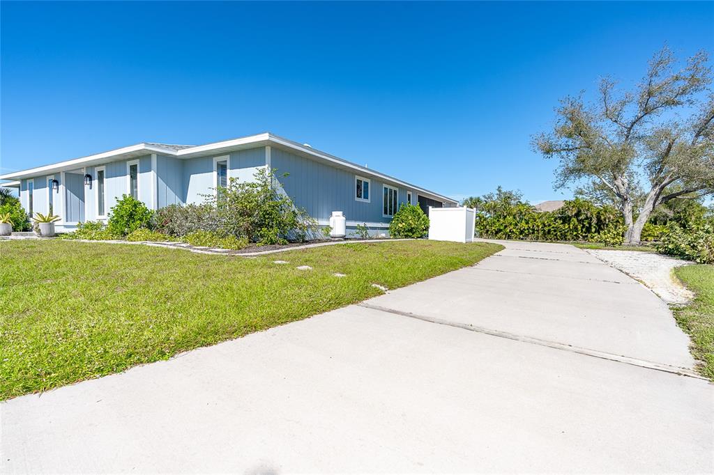 A light blue single-story house with a concrete driveway and a large tree — 320 ANCHOR ROW, PLACIDA, FL
