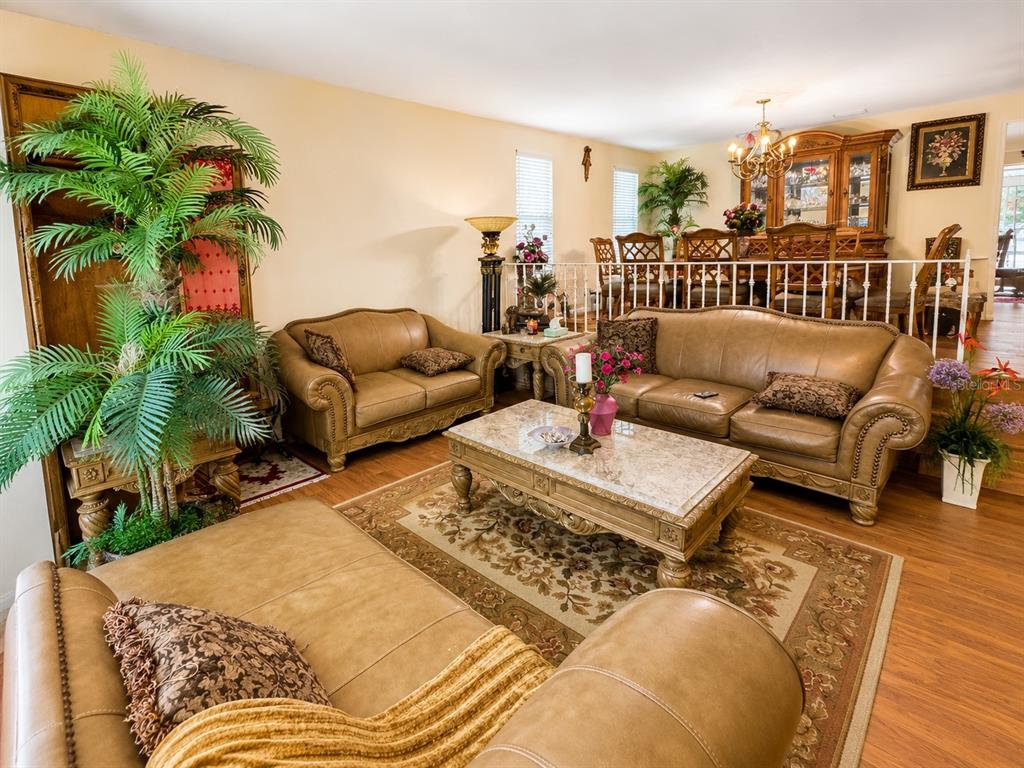A living room features tan leather sofas, a marble coffee table, and a dining area — 3146 CARLOS DRIVE, DUNEDIN, FL