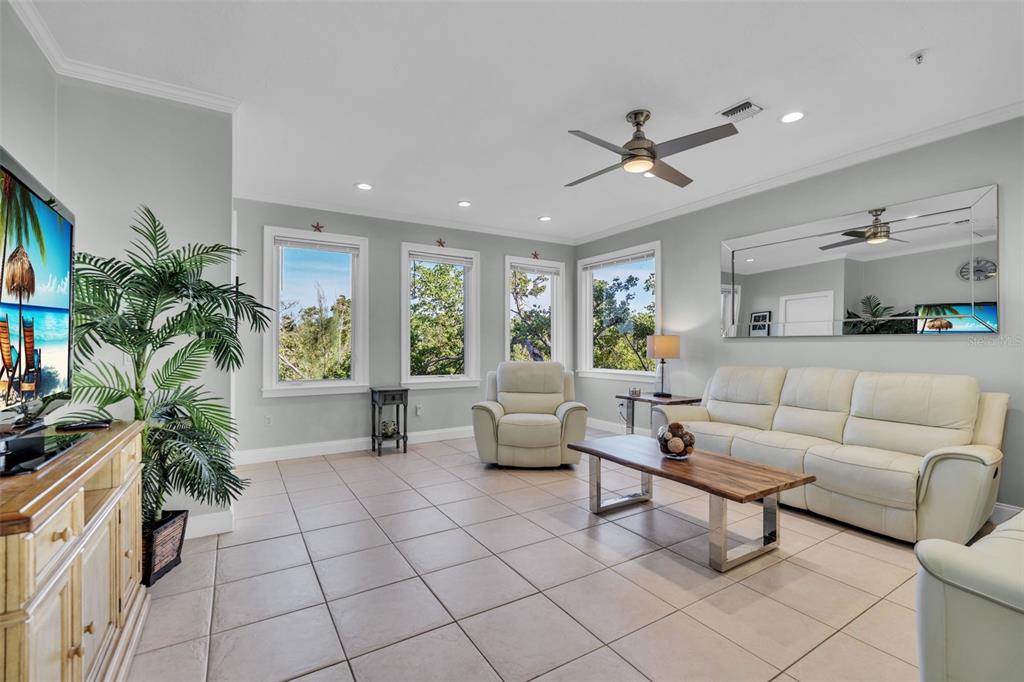 A living room features light tile flooring, a white sofa, a recliner, and large windows — 848 EVERGREEN WAY, LONGBOAT KEY, FL