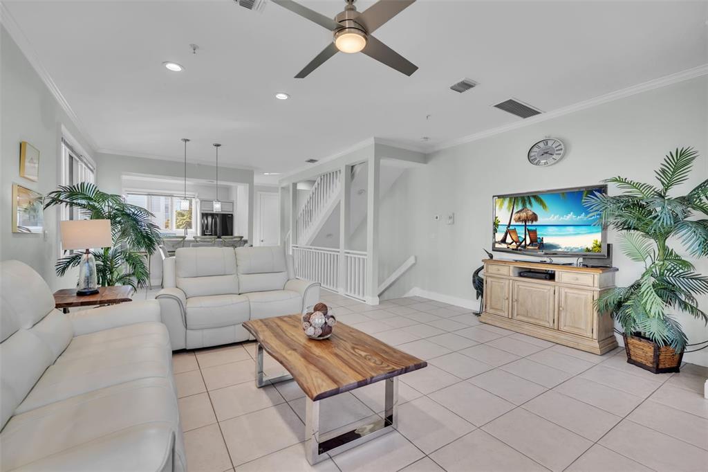 A living room features white leather sofas, a wooden coffee table, and tile flooring — 848 EVERGREEN WAY, LONGBOAT KEY, FL