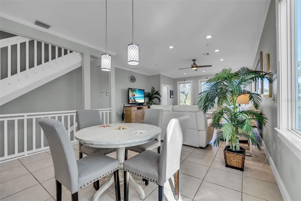 A dining area with a round table and four chairs sits before a living room — 848 EVERGREEN WAY, LONGBOAT KEY, FL