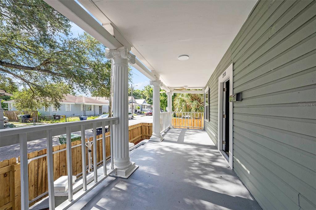 A covered front porch features white columns, a gray floor, and light green siding — 2920 N 17TH STREET, TAMPA, FL