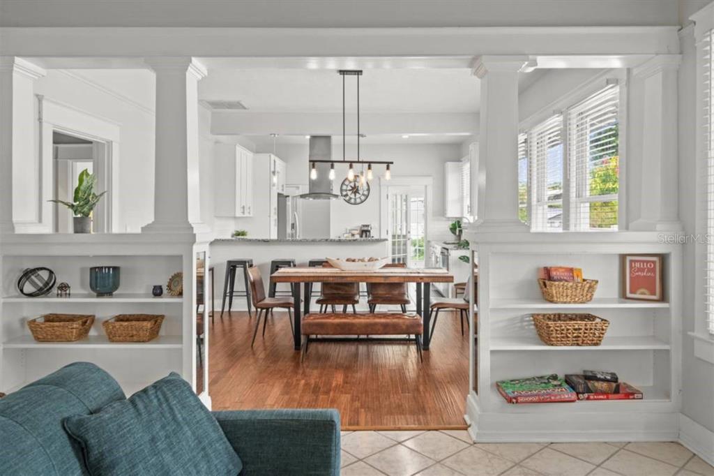 A dining room with a wooden table and chairs sits adjacent to a living area — 7002 N CAMERON AVENUE, TAMPA, FL