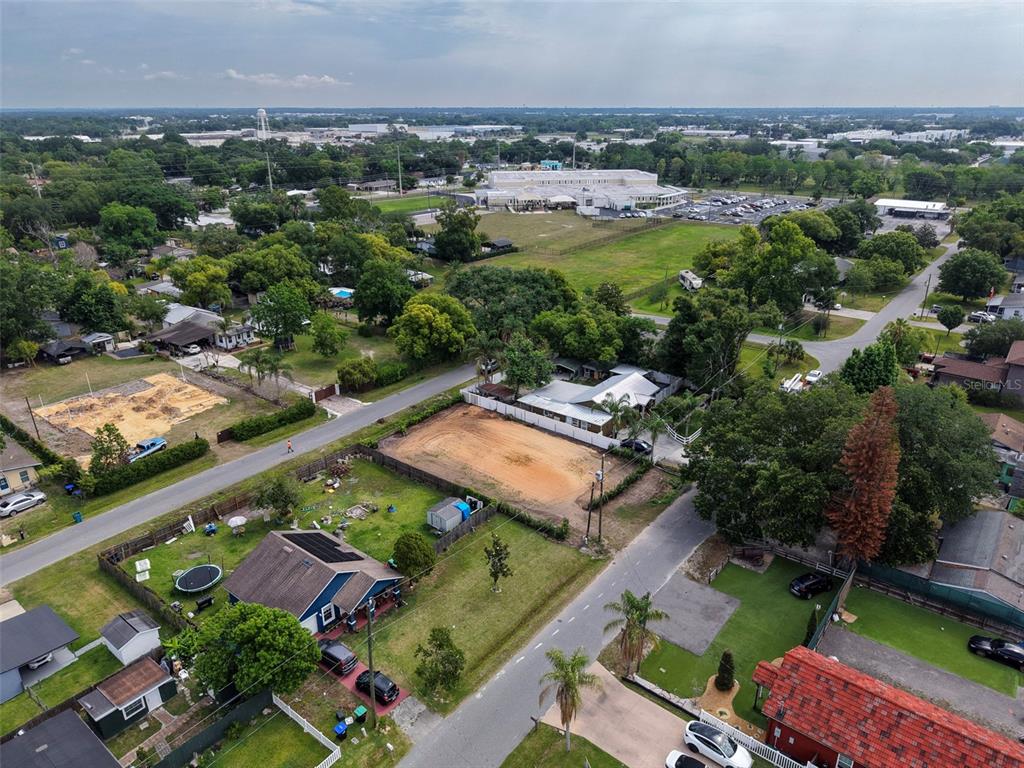 An aerial view shows a residential neighborhood with houses, fenced yards, and a vacant lot — 441 E CYPRESS STREET, WINTER GARDEN, FL