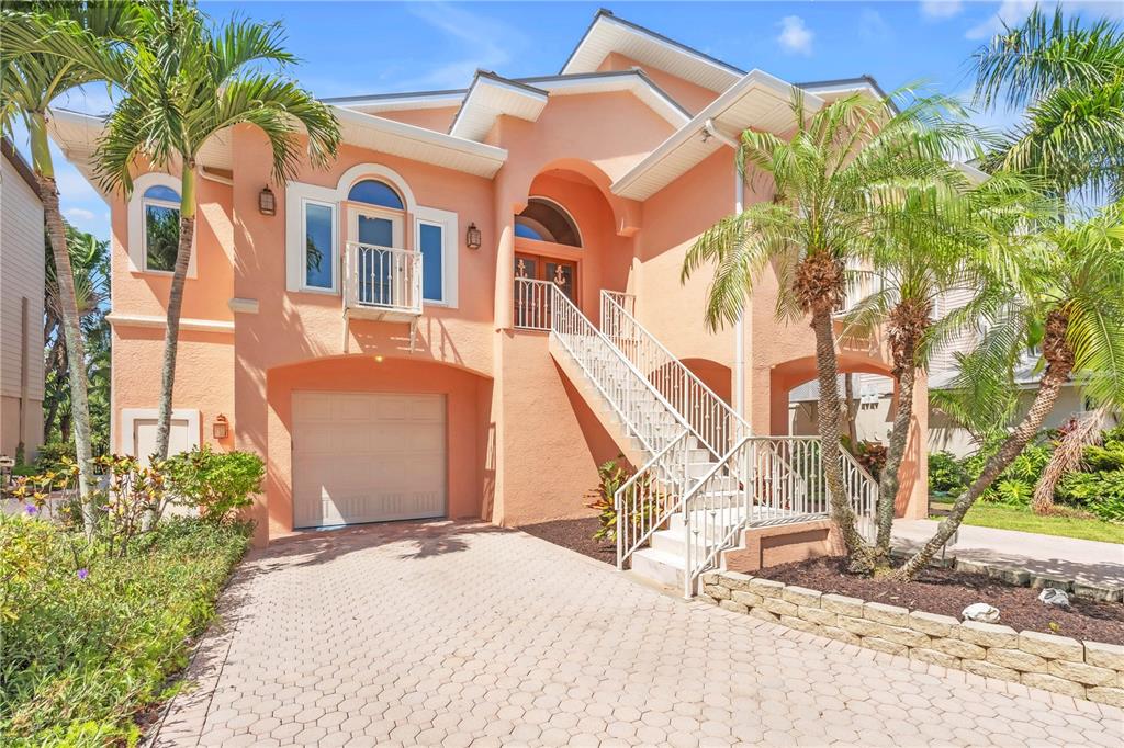 A peach-colored two-story house with a garage, a front staircase, and palm trees — 1508 BOWLEES COVE, BRADENTON, FL