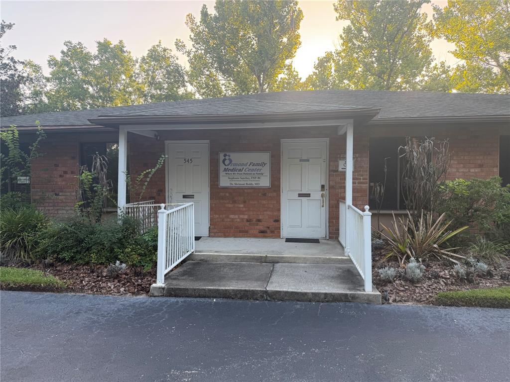 The exterior of a brick medical office building features two white doors and a sign — 545 W GRANADA BOULEVARD, ORMOND BEACH, FL