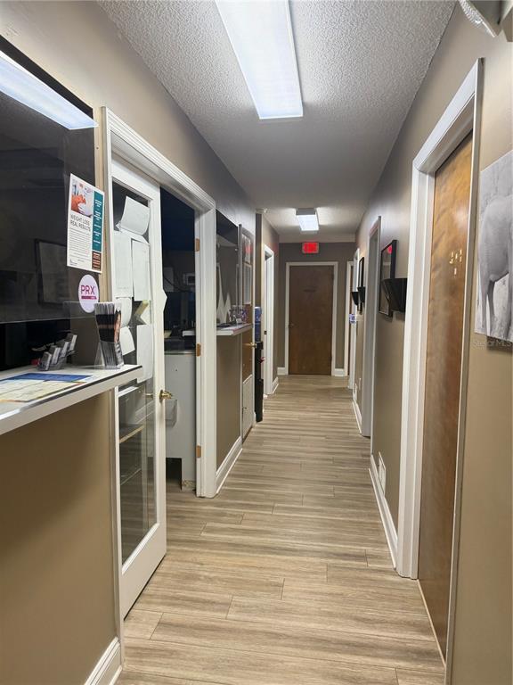A narrow hallway features wood-look flooring, beige walls, and several wooden doors — 545 W GRANADA BOULEVARD, ORMOND BEACH, FL