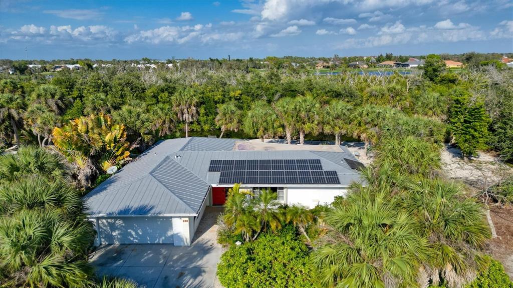 An aerial view of a single-story house with a metal roof and solar panels — 120 BARRACUDA DRIVE, PLACIDA, FL