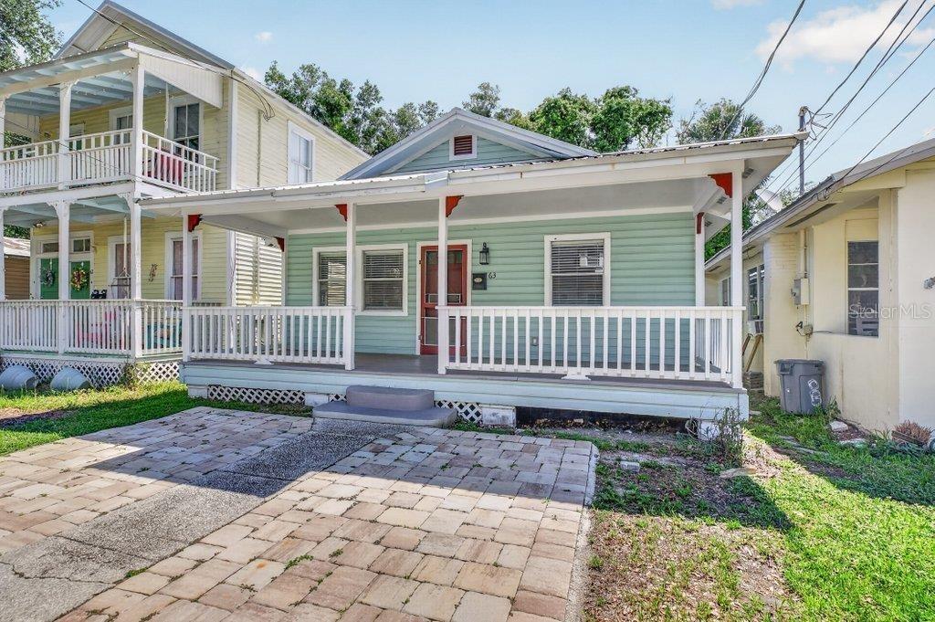 A light green single-story house with a front porch and a paved driveway — 63 DUMAS STREET, ST AUGUSTINE, FL