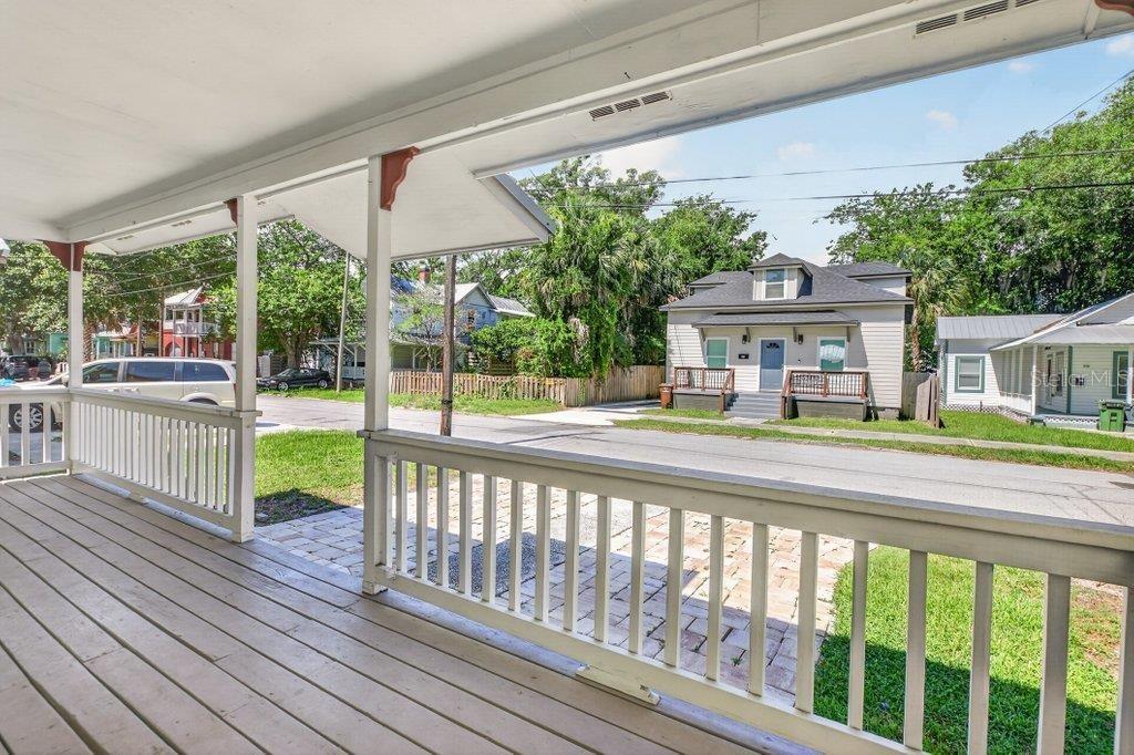 A view from a wooden front porch looking out toward a residential street and houses — 63 DUMAS STREET, ST AUGUSTINE, FL