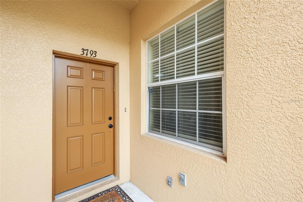 A tan exterior wall features a brown front door with the number 3793 above it — 3793 PARKRIDGE CIRCLE UNIT 3-105, SARASOTA, FL