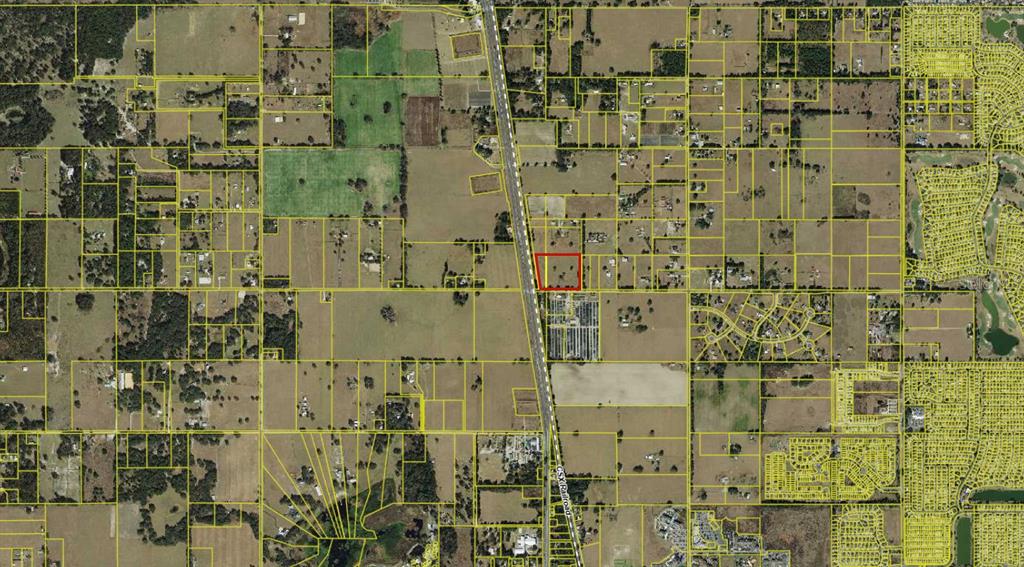 This aerial map shows a rectangular property outlined in red adjacent to a railroad track — 4040 COUNTY ROAD 104, OXFORD, FL