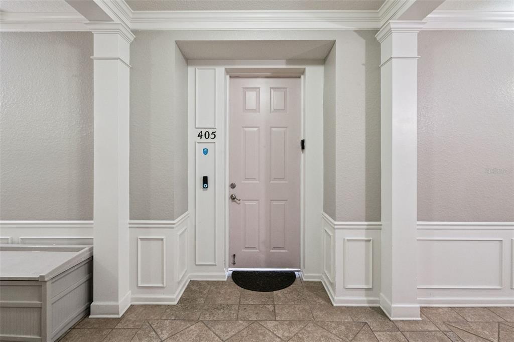 A light-colored apartment door labeled 405 is framed by white columns and wainscoting — 4840 CAYVIEW AVENUE UNIT 405, ORLANDO, FL