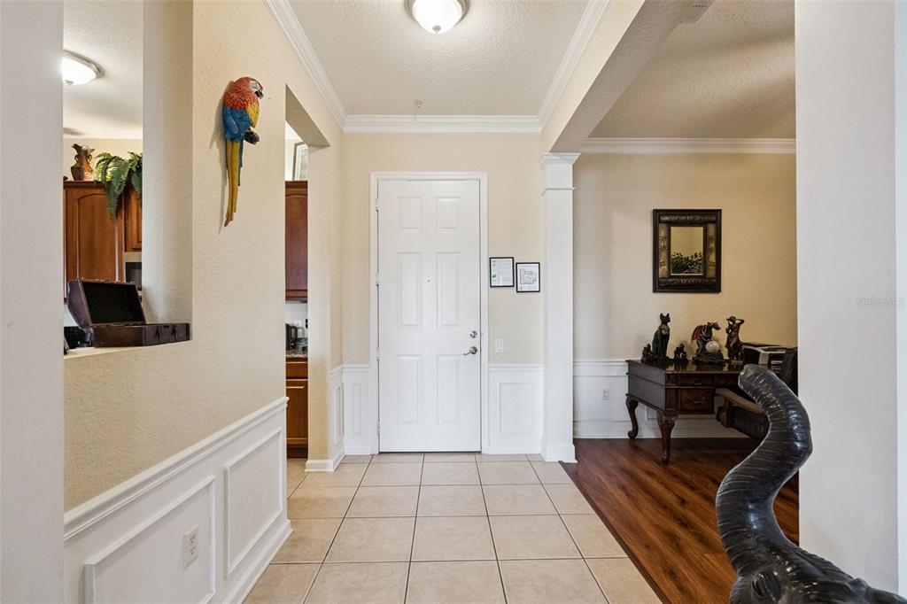 An entryway with tile flooring, a white front door, and a wooden desk to the right — 4840 CAYVIEW AVENUE UNIT 405, ORLANDO, FL