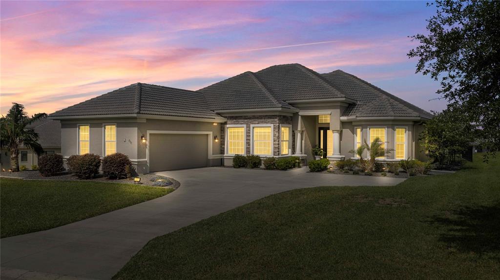 A single-story house with a gray tile roof, stone accents, and a concrete driveway — 2371 N PEAKVIEW LOOP, HERNANDO, FL
