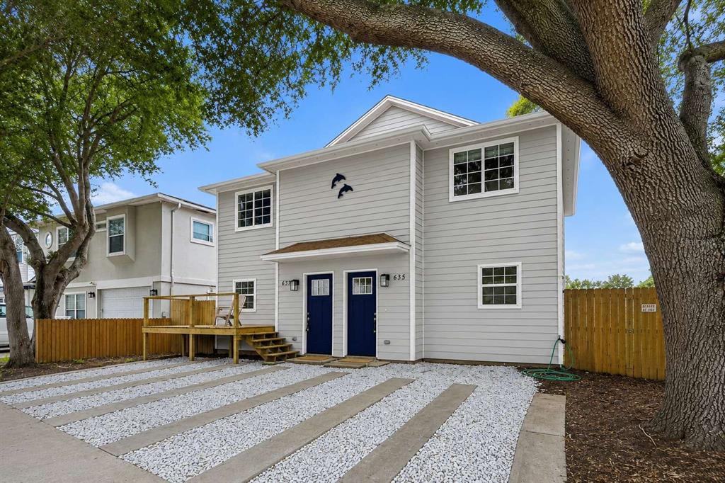 A two-story gray house with two blue front doors and a gravel driveway — 639 6TH AVENUE S, JACKSONVILLE BEACH, FL