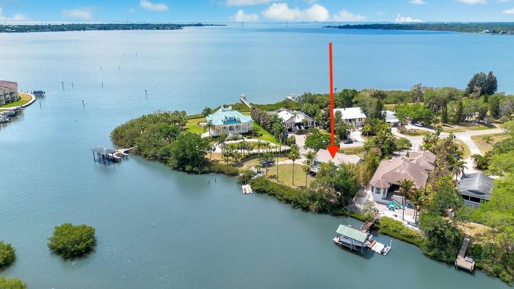A two-story house with light gray siding and a paved driveway sits on a grassy lot — 3858 SHORE BOULEVARD, OLDSMAR, FL