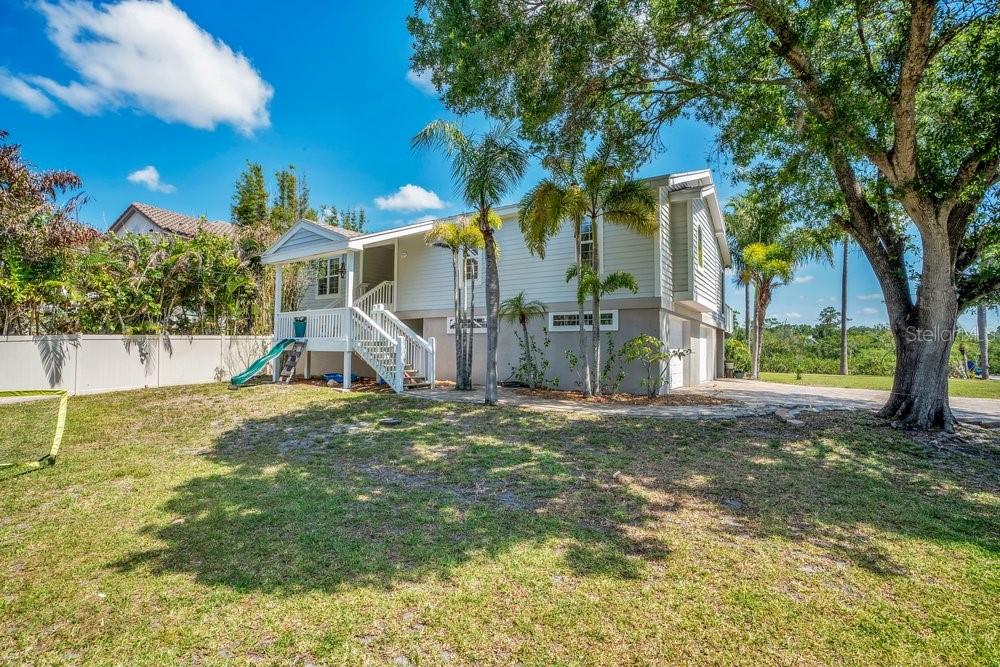 An aerial view shows a waterfront house with a boat dock on a grassy lot — 3858 SHORE BOULEVARD, OLDSMAR, FL