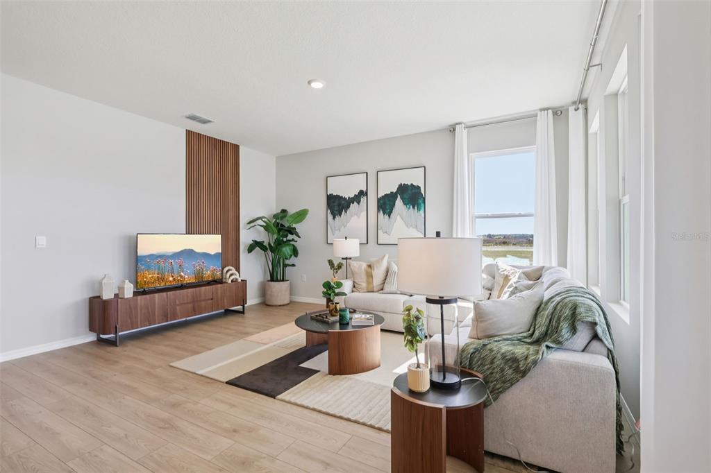 A modern living room features wood-look flooring, a slatted wood accent wall, and a sectional sofa — 8595 HEMPSTEAD WAY, MOUNT DORA, FL
