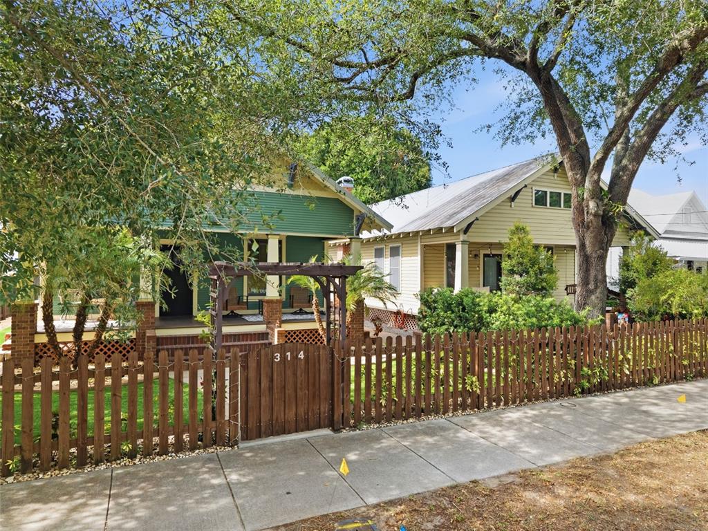 A front porch with brick steps, columns, and string lights leads to a wooden front door — 316 E FRANCES AVENUE, TAMPA, FL