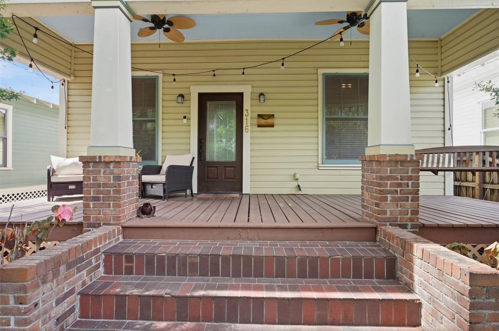 A living room with hardwood floors, a brown leather sofa, and an arched entryway — 316 E FRANCES AVENUE, TAMPA, FL
