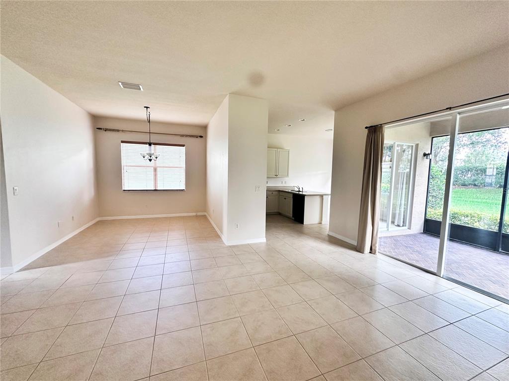 An open-concept living area features tile flooring, a dining space, and a sliding glass door — 4950 SANDY BROOK CIRCLE, WIMAUMA, FL