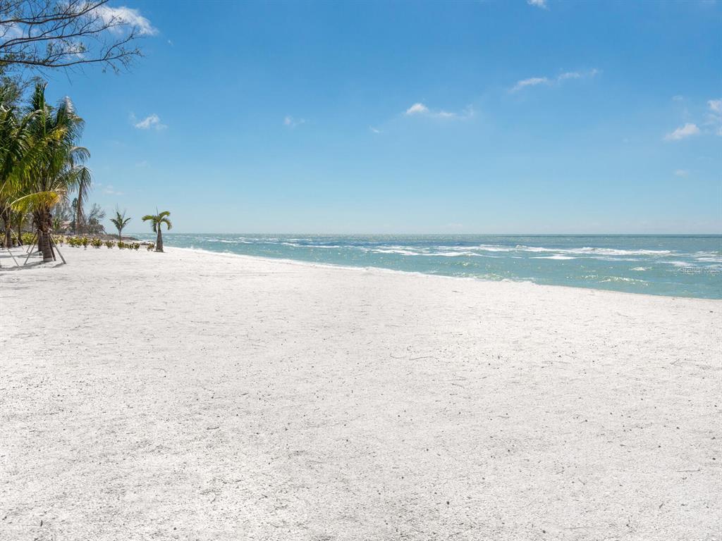 A wide, white sand beach meets the ocean under a clear blue sky — 1216 N CASEY KEY ROAD, OSPREY, FL