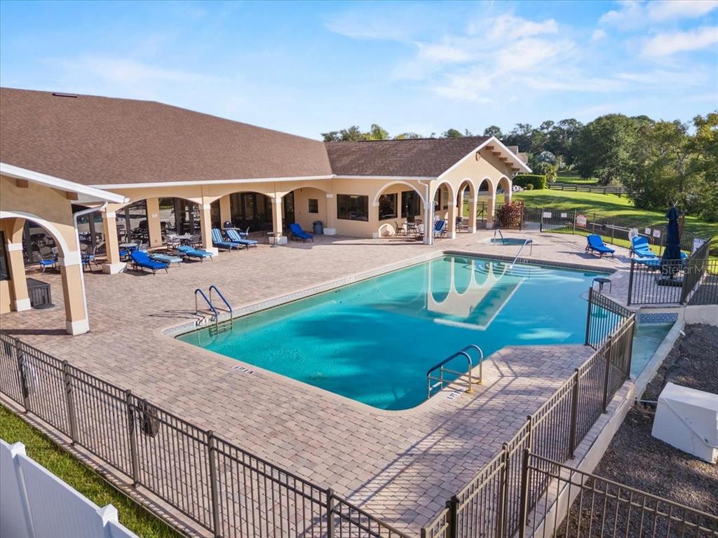 An outdoor swimming pool with a surrounding patio area and a covered building exterior — 118 LAYNEWADE ROAD, POLK CITY, FL