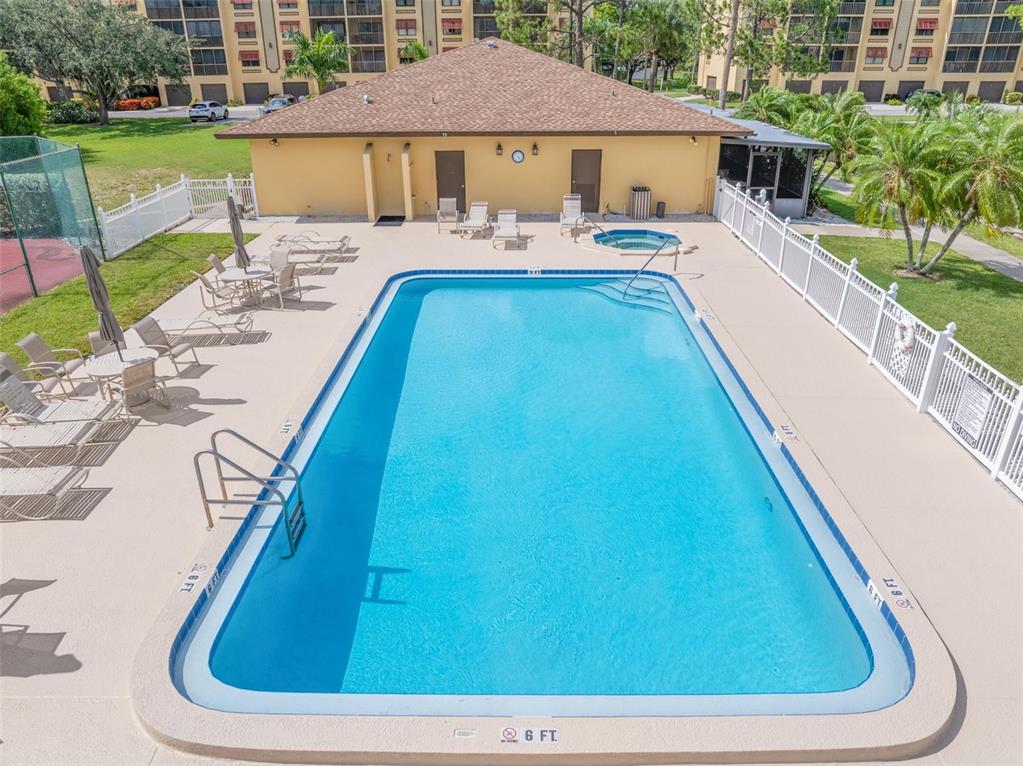 A kitchen with white cabinets, stainless steel appliances, and a breakfast bar overlooking a room — 5817 PARK STREET N UNIT 302, ST PETERSBURG, FL
