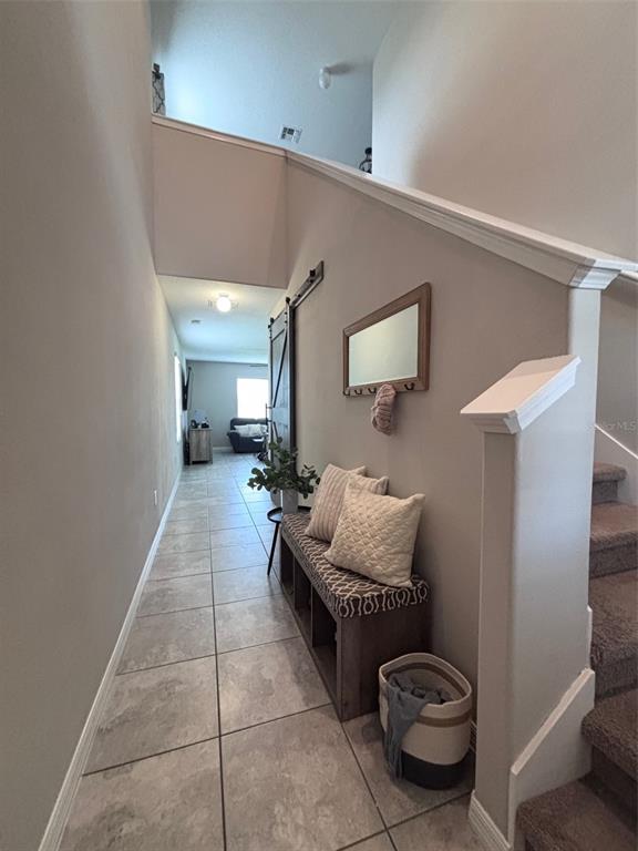 A hallway features a tiled floor, a wooden bench with cushions, and a staircase — 405 SERENITY MILL LOOP, RUSKIN, FL