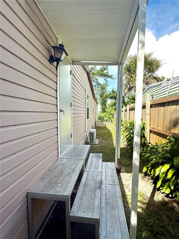 A side exterior view shows a metal staircase leading to a door under a porch — 3603 SE 35TH AVENUE, OKEECHOBEE, FL