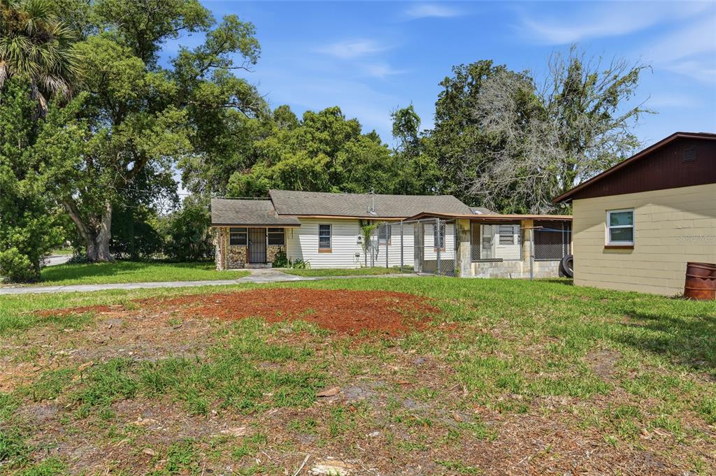 A single-story house with white siding and a stone facade sits behind a grassy yard — 307 LEMON STREET, MAITLAND, FL