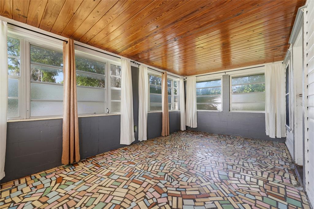 A sunroom features a wood-paneled ceiling, gray block walls, and a colorful mosaic tile floor — 307 LEMON STREET, MAITLAND, FL