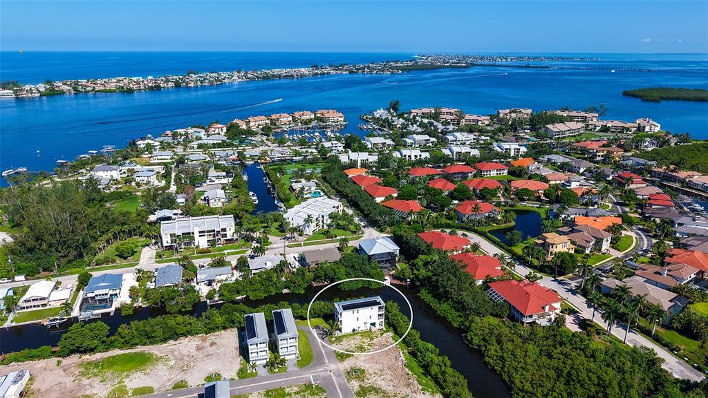 An aerial view shows a white house circled in a residential neighborhood near the water — 12435 DOCKSIDE TERRACE, CORTEZ, FL