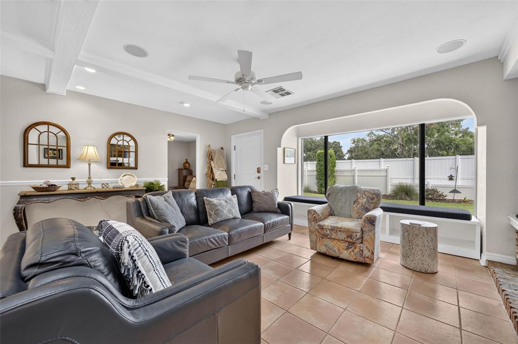 A living room features leather sofas, a patterned armchair, tile flooring, and a large bay window — 790 S LAKE SYBELIA DRIVE, MAITLAND, FL