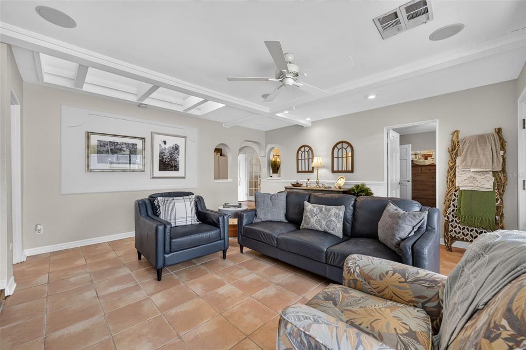 A living room features tile flooring, a coffered ceiling, a dark sofa, and an armchair — 790 S LAKE SYBELIA DRIVE, MAITLAND, FL