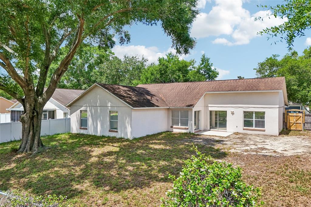The exterior rear view of a single-story house features a brown roof and light-colored walls — 2596 ALCLOBE CIRCLE, OCOEE, FL