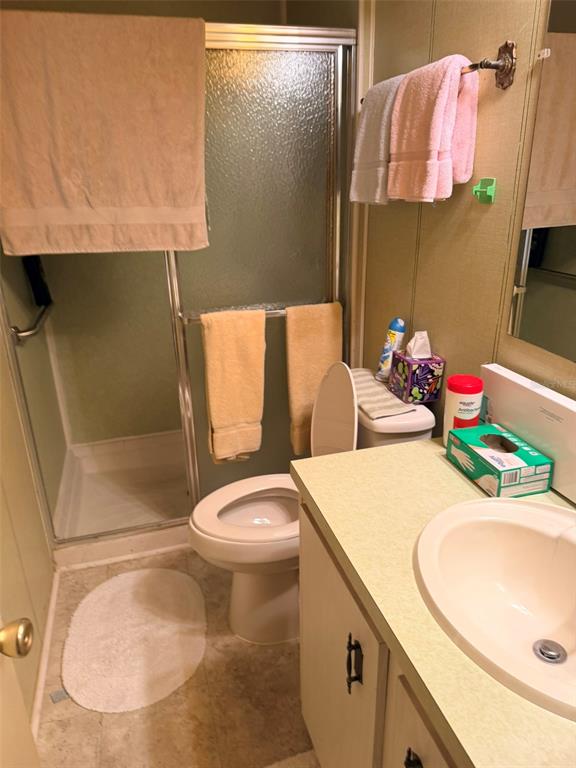 A bathroom features a walk-in shower, a toilet, and a vanity with a sink — 3301 ALT 19 UNIT 267, DUNEDIN, FL