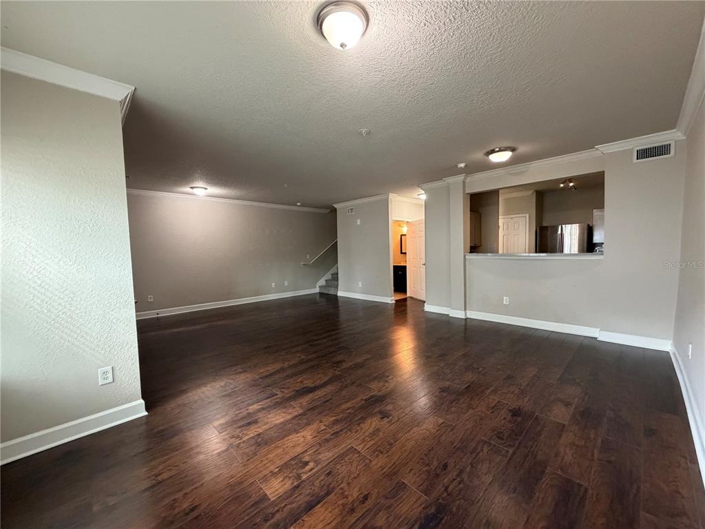 A gated entrance leads to a covered driveway beneath a multi-story white apartment building — 204 SOUTH STREET UNIT 1053, ORLANDO, FL